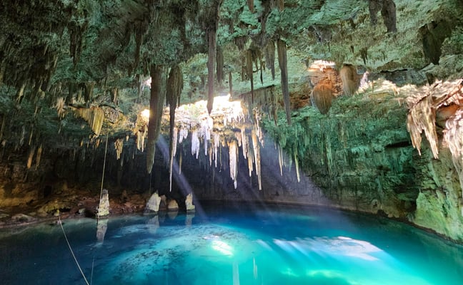 Underground cenote with turquoise water and stalactites
