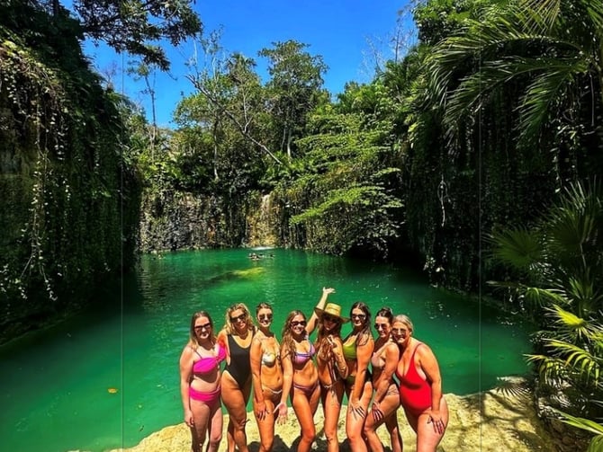Cenote with turquoise water surrounded by jungle